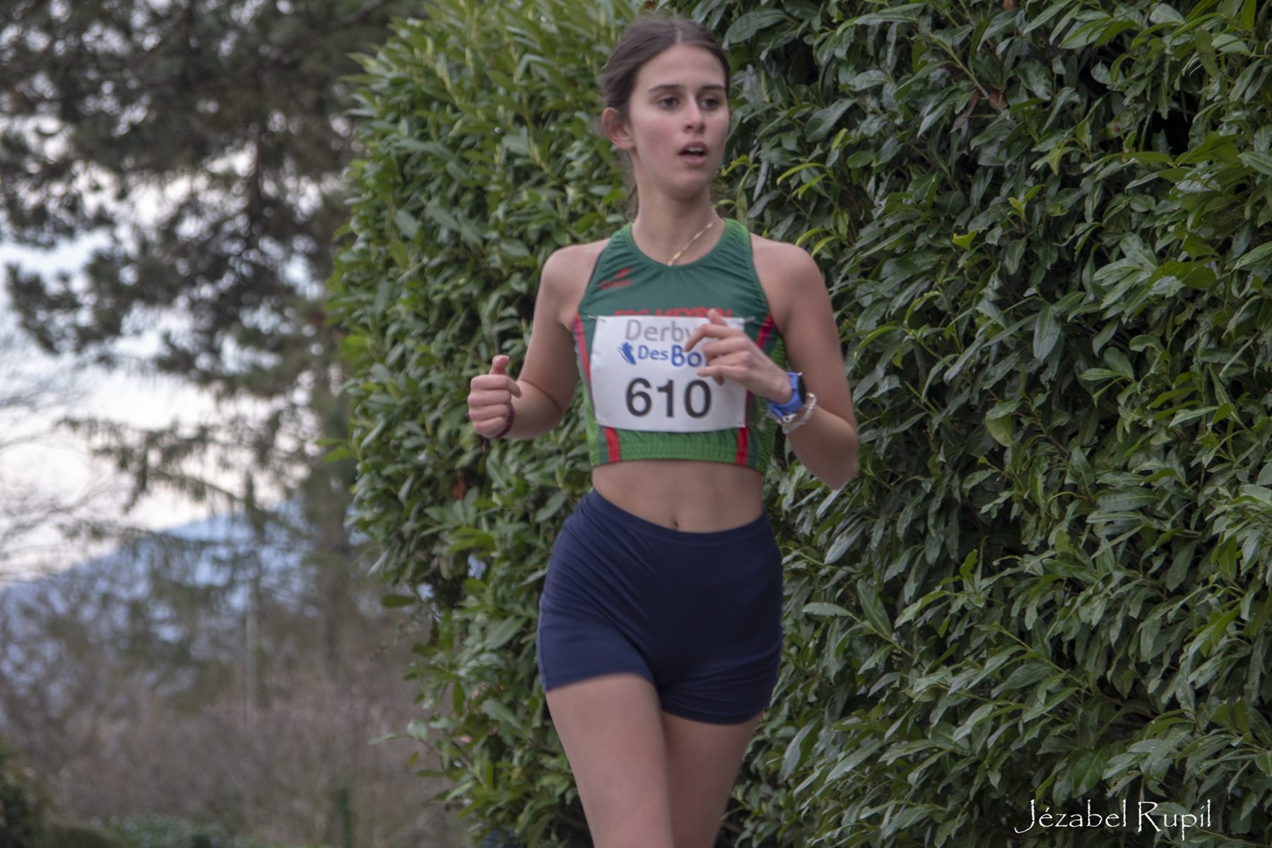 A runner passing a hedge along the course